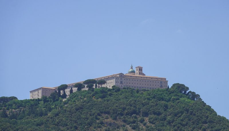 The Abbey of Monte Cassino on its mountain top, white against a blue sky.