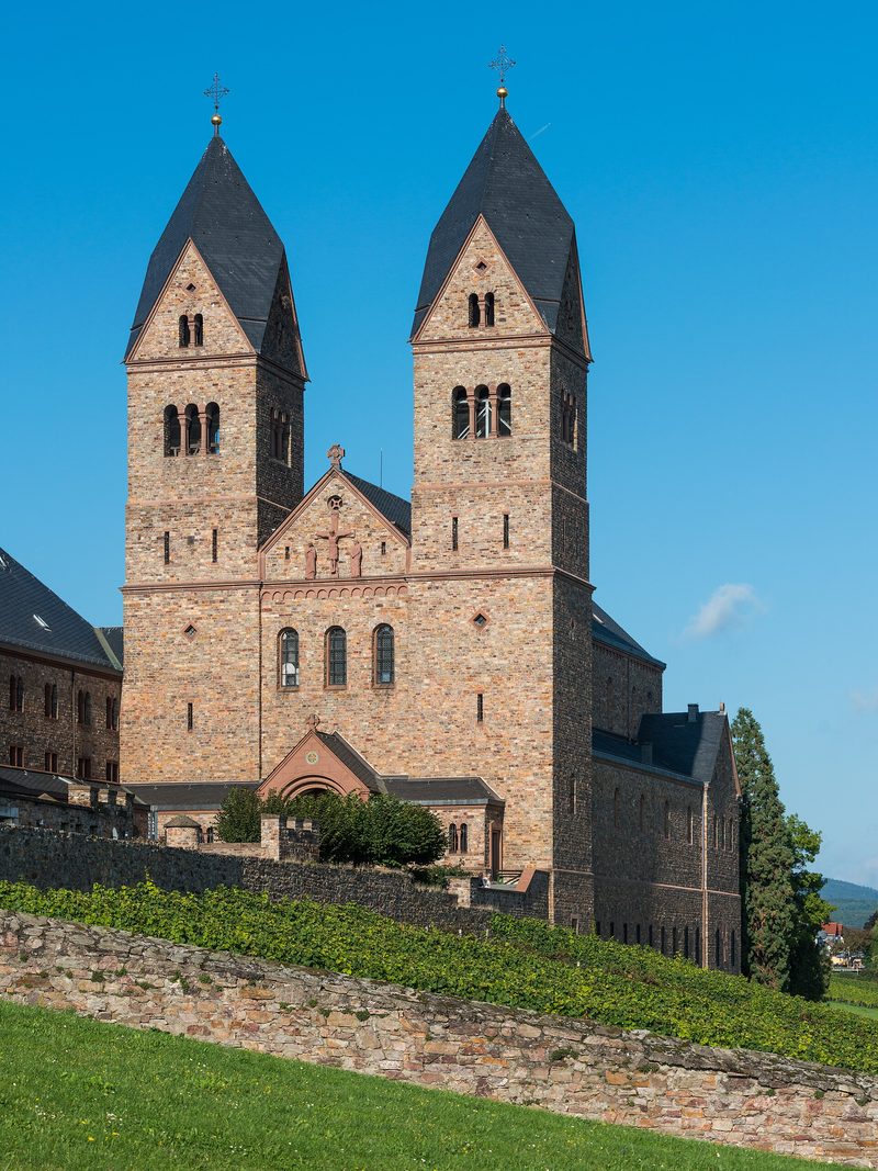 The Abbey of St. Hildegard above Rüdesheim: a red sandstone church with two square towers over vineyards.
