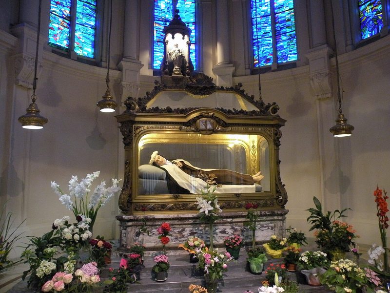 The chapel of the Carmel of Lisieux: a statue of St. Thérèse lies in a shrine surrounded by flowers and candles.