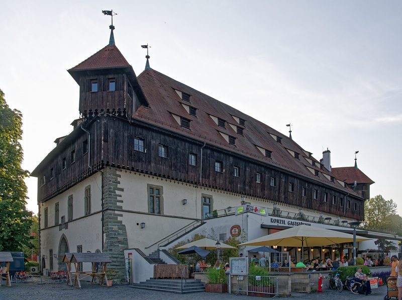 Photograph of the Council Building in Konstanz, a large medieval hall with a steep tiled roof, by the water.