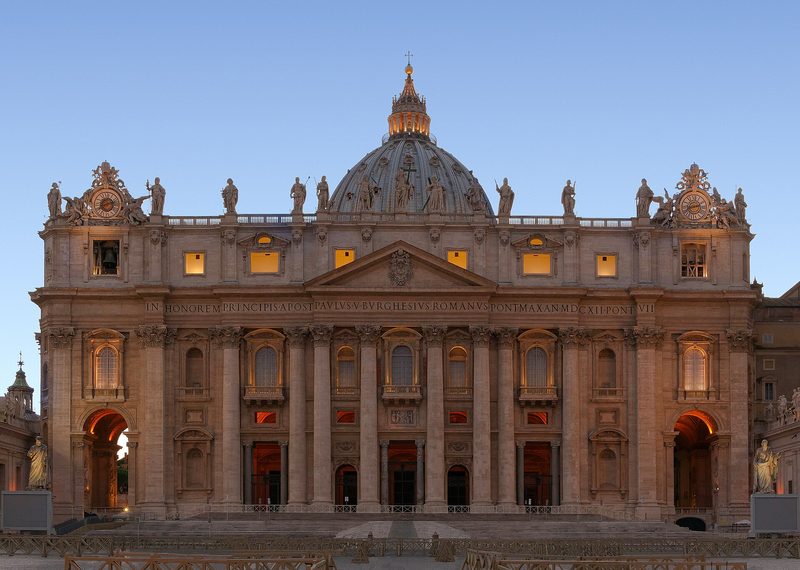 Photograph of the facade and dome of St. Peter’s Basilica at dusk.