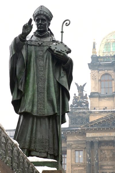 Bronze statue of St. Adalbert as a bishop with a crosier, raising his hand, in Prague.
