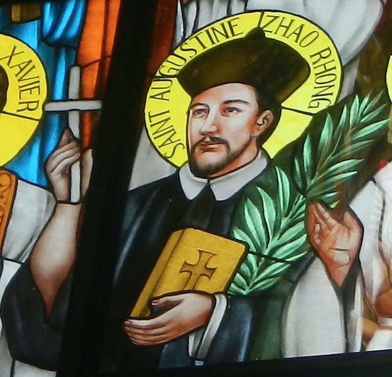 Stained-glass window of St. Augustine Zhao Rong holding a palm and a book.