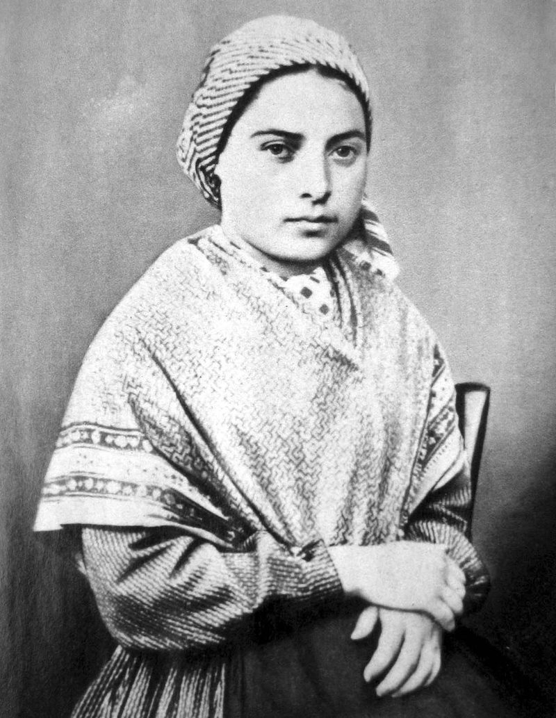 Black-and-white photograph of St. Bernadette as a young woman in a headscarf and shawl.