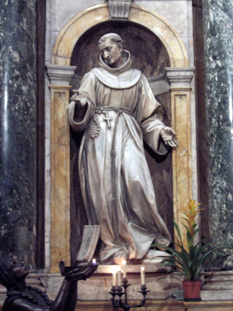 Marble statue of St. Bernardine of Siena in a Franciscan habit, in a niche.