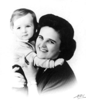 Black-and-white photograph of St. Gianna Molla smiling and hugging a small child.