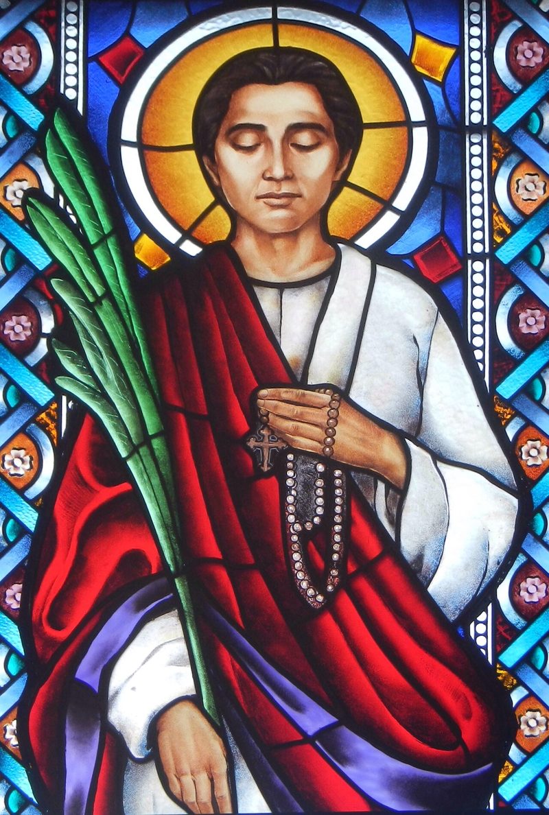 Stained-glass window of St. Lorenzo Ruiz holding a palm and a rosary.